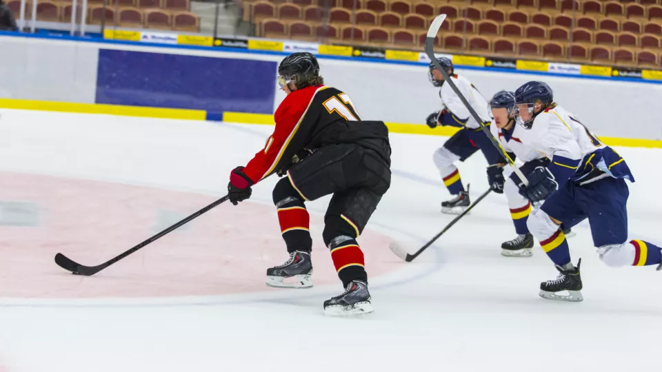 Tre ishockeyspelare jagar efter pucken