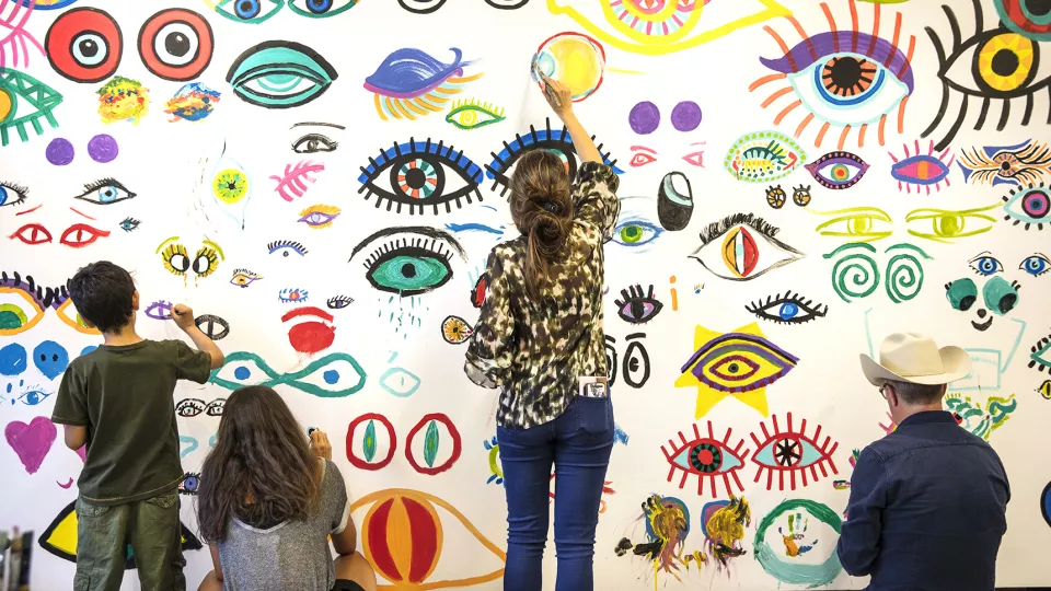 Barn som målar på en vägg. 