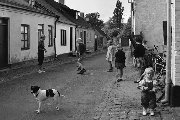 Barn och en hund som leker på en gata i Malmö.