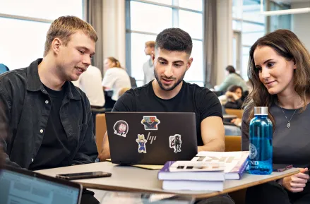 Tre studenter med laptops. Foto.