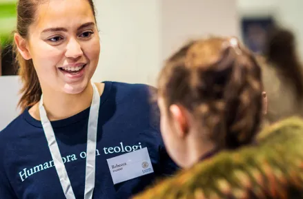 Studentambassadör pratar med mässbesökare. Foto.