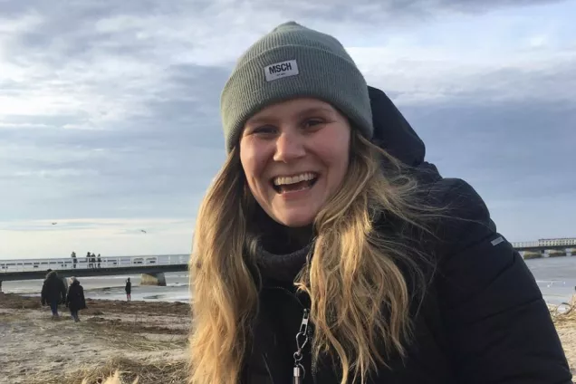 Klara Sundell sitter på en strand. Foto.