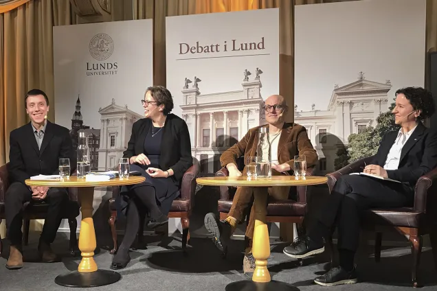 Fyra personer sitter på en scen och diskuterar. Foto.