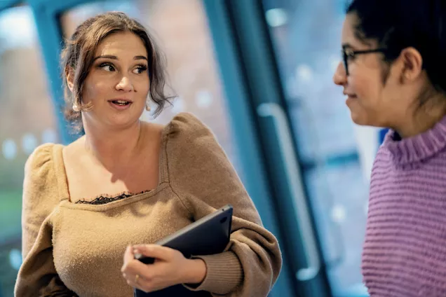 Två studenter samtalar. Foto.