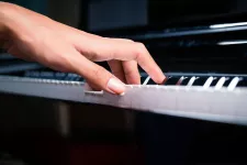 bild på en hand som spelar på ett piano