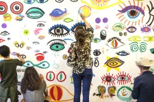 Barn som målar på en vägg. 