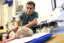 Manlig läkare undersöker liten pojke. Foto.