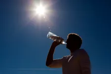man dricker vatten under sol