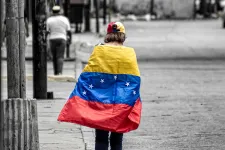 Person seen from the back, draped with a Venezuelan flag.