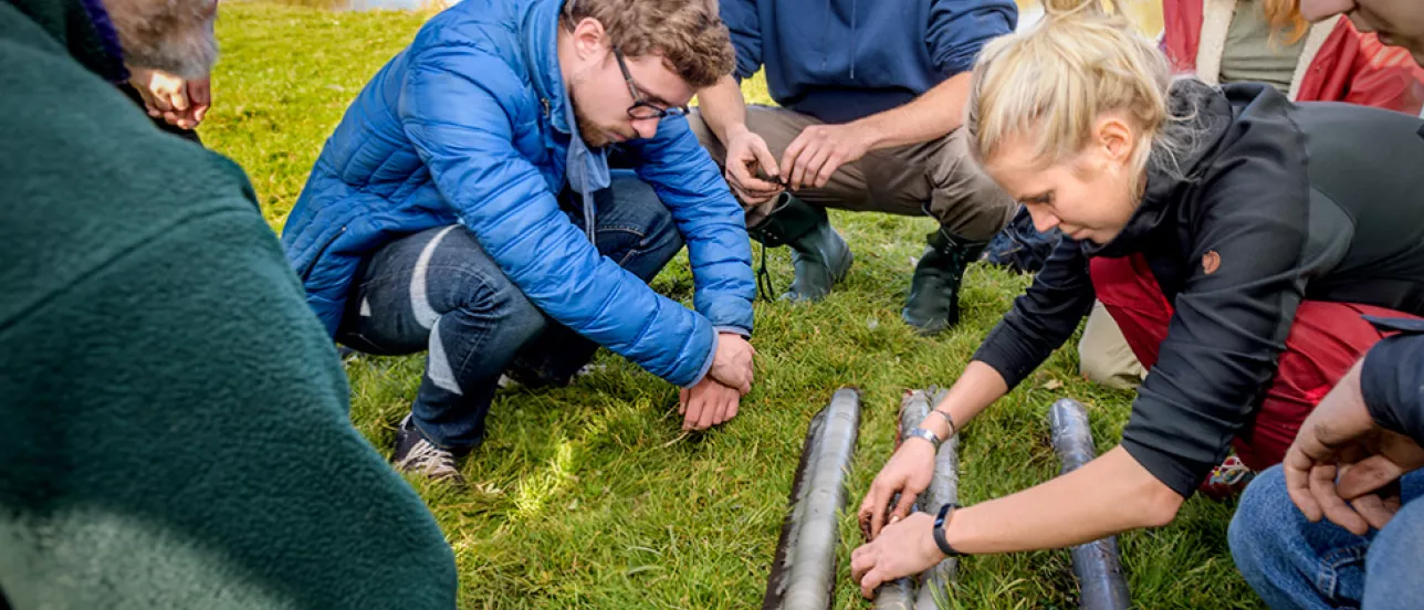 Studenter tittar på sediment. Foto.