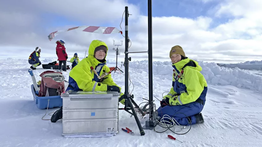 Två forskare sitter på isen i Arktis. Foto. 
